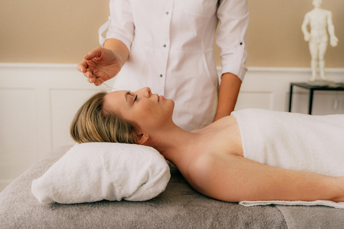 Acupuncture needle inserted into a person’s hand during a treatment session.